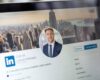 LinkedIn profile on laptop screen with city view.